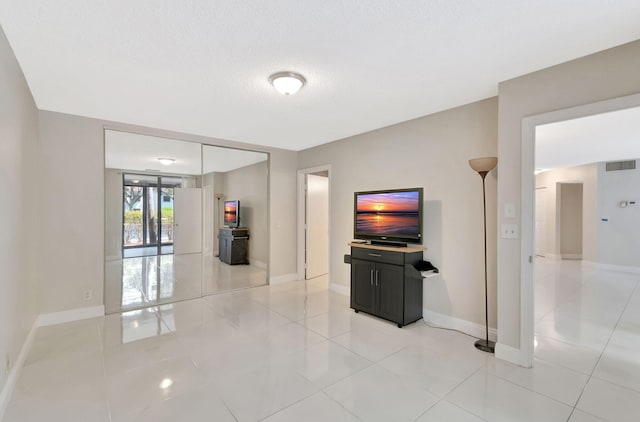 interior space with baseboards, visible vents, and light tile patterned floors