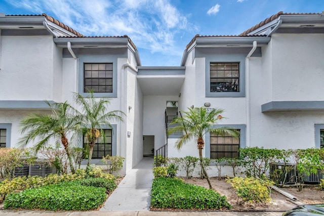 doorway to property with a tile roof and stucco siding