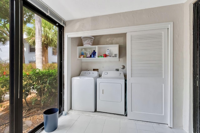 washroom with separate washer and dryer, laundry area, and light tile patterned floors