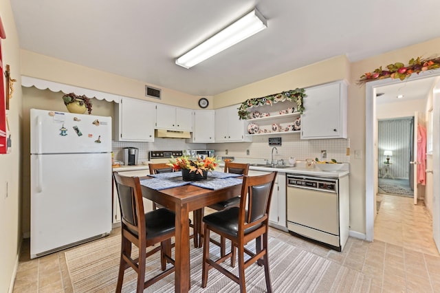 2104 S 26th St, Fort Pierce, FL 34947 - kitchen with white appliances, a sink, under cabinet range hood, backsplash, and light countertops