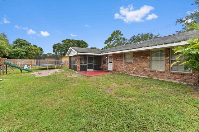 2104 S 26th St, Fort Pierce, FL 34947 - view of yard featuring a sunroom, a trampoline, and a playground