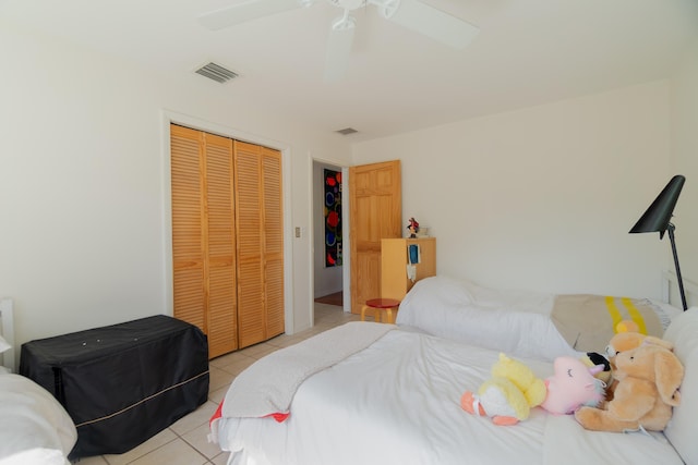 bedroom with visible vents, ceiling fan, light tile patterned flooring, and a closet