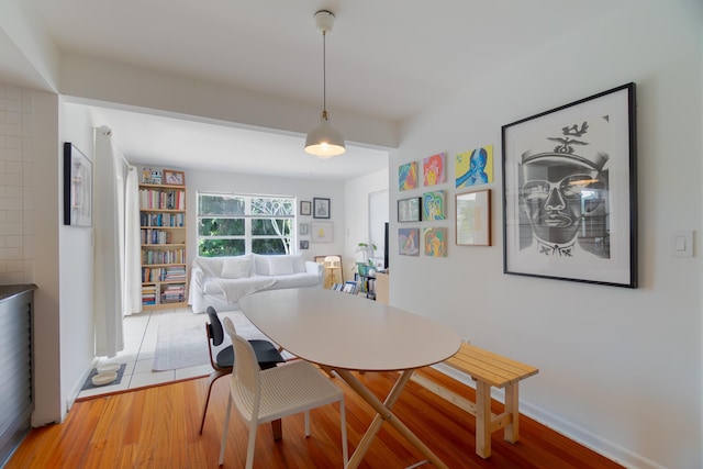 dining space featuring baseboards and light wood-style floors
