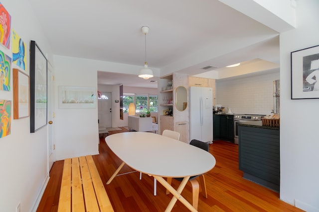dining space featuring light wood-type flooring and visible vents