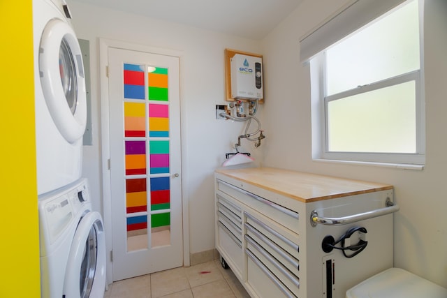 laundry room with tankless water heater, light tile patterned floors, and stacked washer and clothes dryer