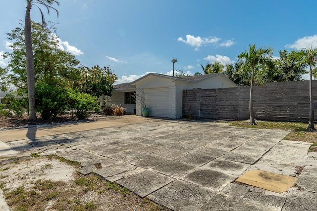 exterior space featuring fence, stucco siding, and a garage