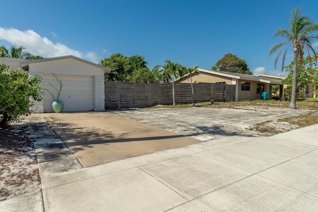 exterior space featuring fence, stucco siding, and driveway