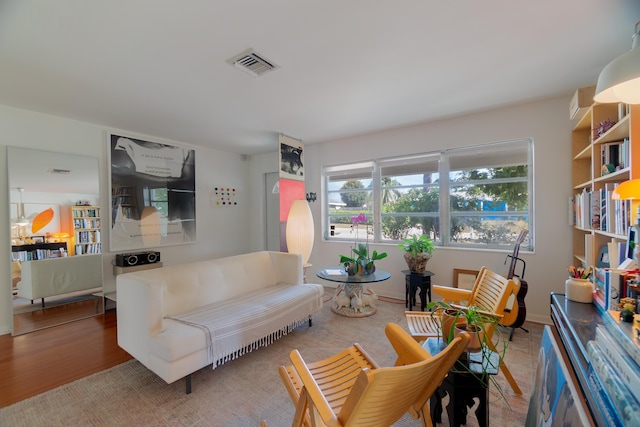 living area featuring visible vents and wood finished floors