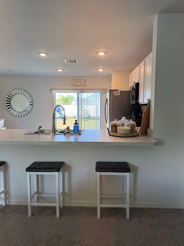 133SW SW Becker Rd, Port Saint Lucie, FL 34953 - kitchen with a sink, light countertops, a kitchen breakfast bar, freestanding refrigerator, and visible vents