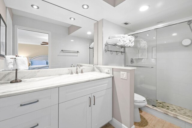 bathroom with vanity, toilet, recessed lighting, and a stall shower