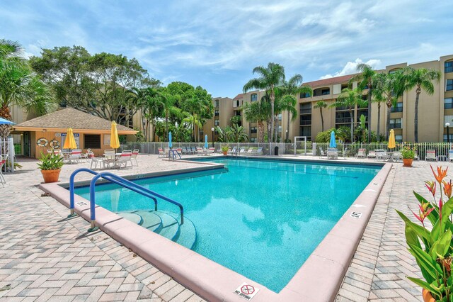 community pool featuring fence and a patio