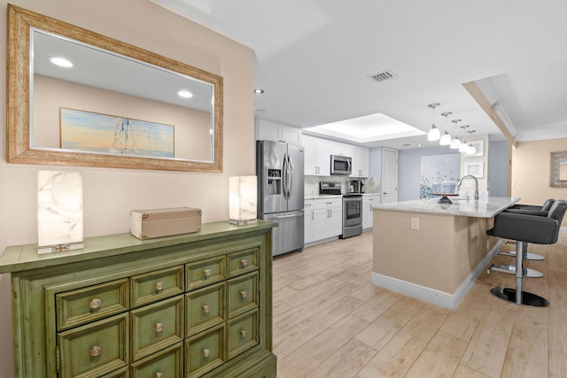 kitchen with visible vents, green cabinetry, white cabinetry, light wood-style flooring, and stainless steel appliances