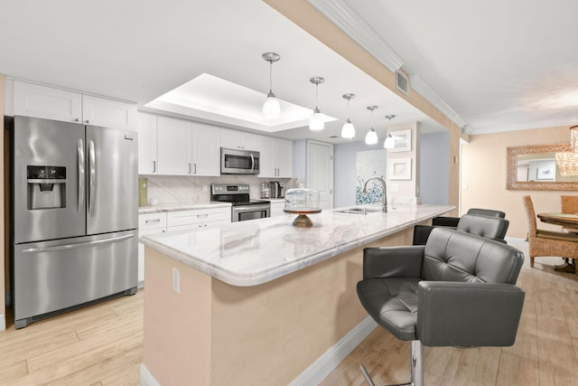 kitchen featuring baseboards, white cabinetry, a sink, light wood finished floors, and stainless steel appliances