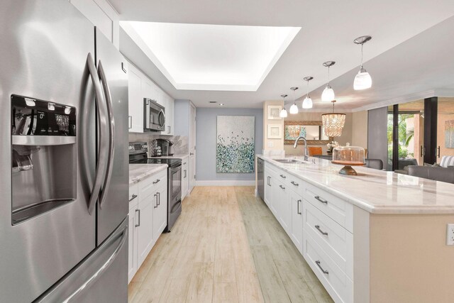 kitchen featuring light wood-style floors, a sink, white cabinets, and stainless steel appliances
