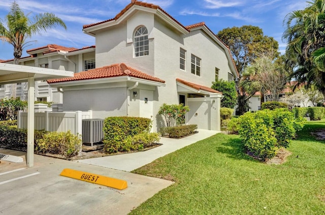 7669 Springwater Pl Unit 202, Boynton Beach, FL 33437 - view of front of property featuring a tile roof, parking, central AC unit, fence, and a front lawn