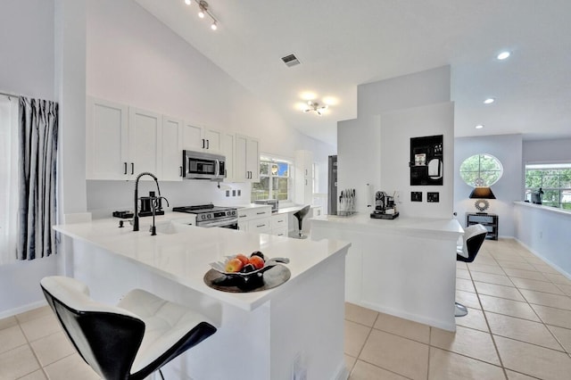 7669 Springwater Pl Unit 202, Boynton Beach, FL 33437 - kitchen featuring light countertops, stainless steel appliances, light tile patterned flooring, and a peninsula