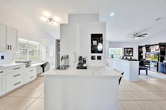 7669 Springwater Pl Unit 202, Boynton Beach, FL 33437 - kitchen with light countertops, white cabinetry, light tile patterned floors, and vaulted ceiling
