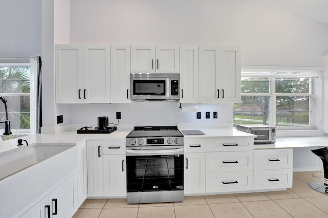 7669 Springwater Pl Unit 202, Boynton Beach, FL 33437 - kitchen with a sink, light countertops, stainless steel appliances, and white cabinetry