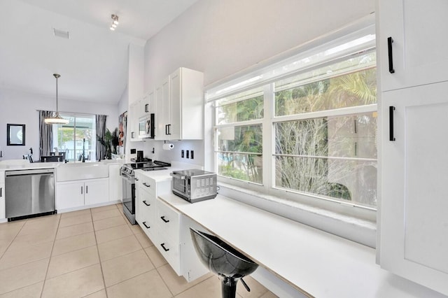 7669 Springwater Pl Unit 202, Boynton Beach, FL 33437 - kitchen with stainless steel appliances, vaulted ceiling, white cabinetry, and light tile patterned floors