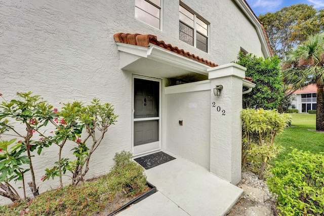 7669 Springwater Pl Unit 202, Boynton Beach, FL 33437 - doorway to property with a tiled roof and stucco siding