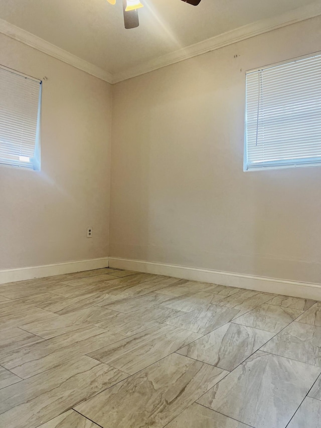 spare room featuring crown molding, plenty of natural light, baseboards, and ceiling fan
