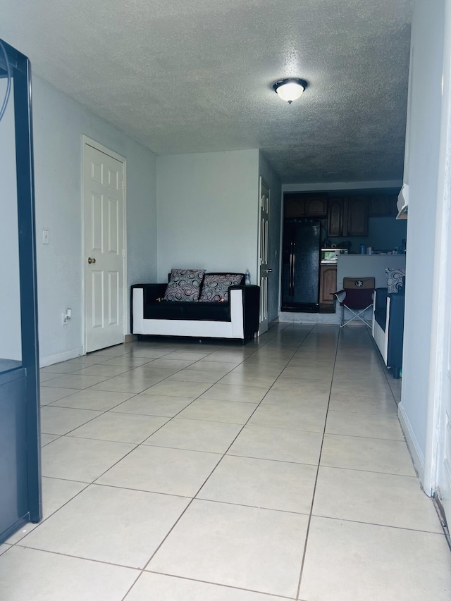 hallway featuring light tile patterned floors and a textured ceiling