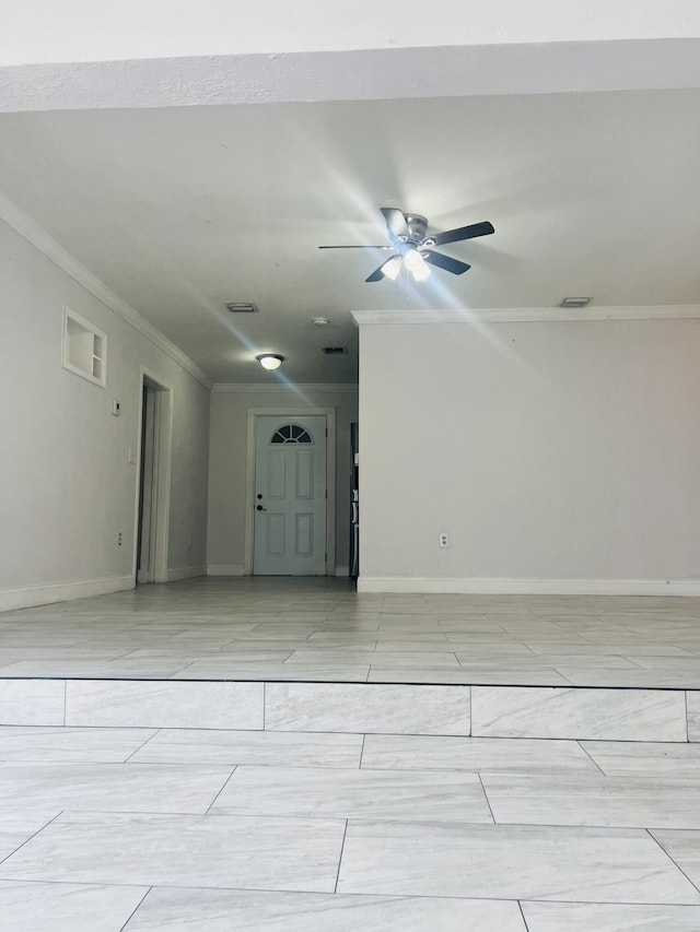 spare room with crown molding, a ceiling fan, baseboards, and visible vents