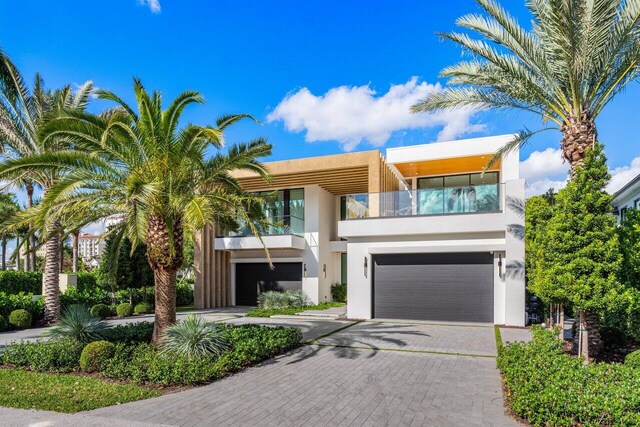 217 Thatch Palm Dr, Boca Raton, FL 33432 - view of front of house featuring stucco siding, a balcony, an attached garage, and decorative driveway