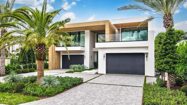 217 Thatch Palm Dr, Boca Raton, FL 33432 - modern home featuring stucco siding, a balcony, a garage, and decorative driveway