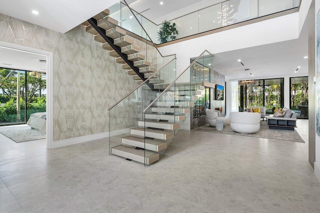 217 Thatch Palm Dr, Boca Raton, FL 33432 - stairway featuring healthy amount of natural light, a towering ceiling, wallpapered walls, and recessed lighting