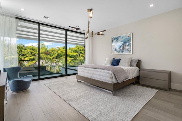 217 Thatch Palm Dr, Boca Raton, FL 33432 - bedroom with access to outside, a chandelier, expansive windows, wood finished floors, and baseboards