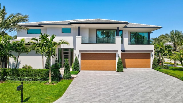 2498 Queen Palm Rd, Boca Raton, FL 33432 - view of front facade with stucco siding, a balcony, a garage, and decorative driveway