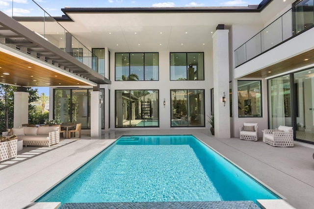2498 Queen Palm Rd, Boca Raton, FL 33432 - back of property featuring stucco siding, a patio, an outdoor hangout area, and an outdoor pool