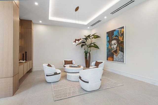 living area with recessed lighting and a raised ceiling