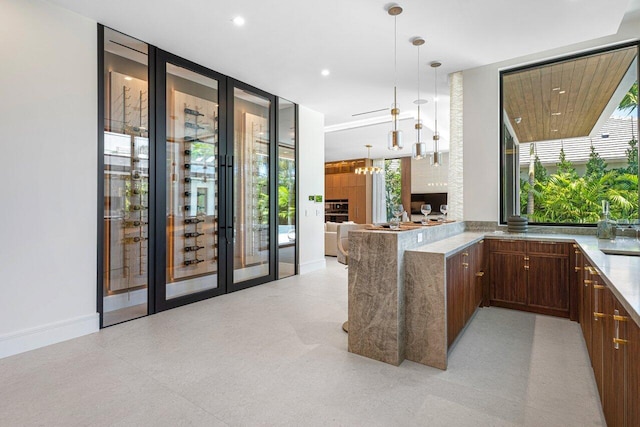kitchen featuring a peninsula, decorative light fixtures, open floor plan, floor to ceiling windows, and recessed lighting