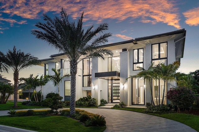view of front of house featuring stucco siding and a front lawn