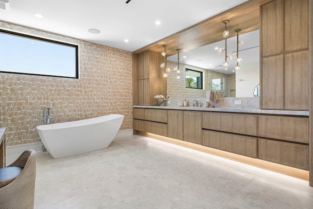 full bathroom with vanity, a soaking tub, and recessed lighting