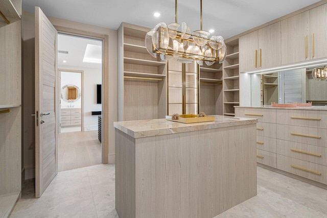 spacious closet with a chandelier