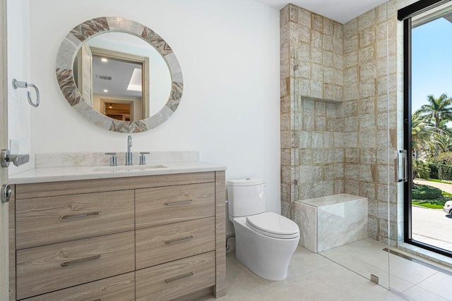 full bathroom featuring vanity, toilet, tile patterned flooring, and tiled shower