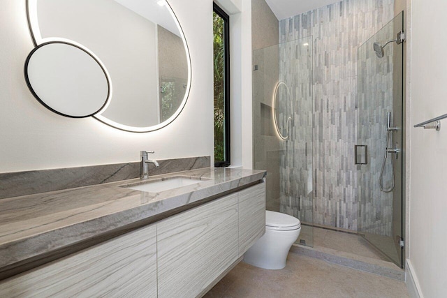 full bath with a stall shower, vanity, and toilet