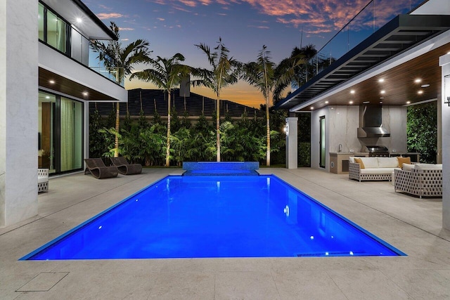 outdoor pool featuring an outdoor kitchen, an outdoor hangout area, and a patio