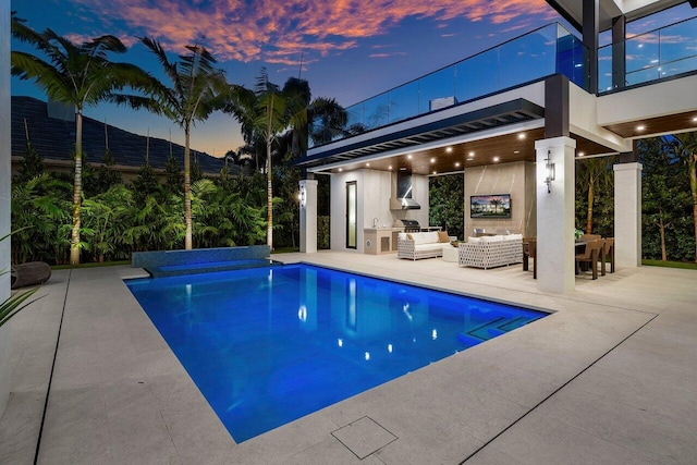 outdoor pool featuring an outdoor living space, exterior kitchen, and a patio