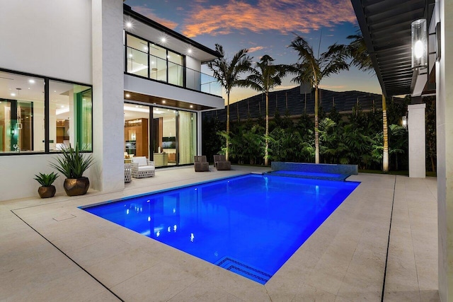 2498 Queen Palm Rd, Boca Raton, FL 33432 - pool at dusk featuring a patio and an outdoor pool