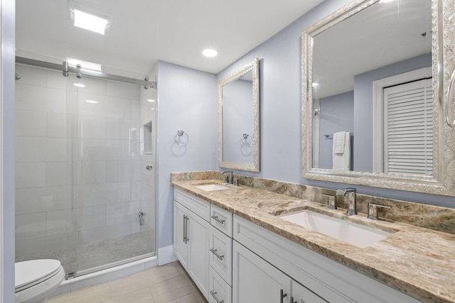 full bath featuring a shower stall, double vanity, toilet, and tile patterned floors