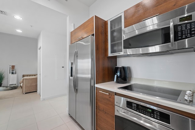 480 Hibiscus St Unit 1003, West Palm Beach, FL 33401 - kitchen featuring light countertops, appliances with stainless steel finishes, modern cabinets, and glass insert cabinets