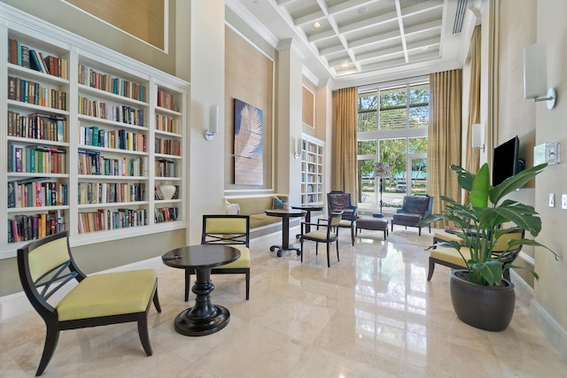 480 Hibiscus St Unit 1003, West Palm Beach, FL 33401 - living area with wall of books, coffered ceiling, a high ceiling, and beamed ceiling