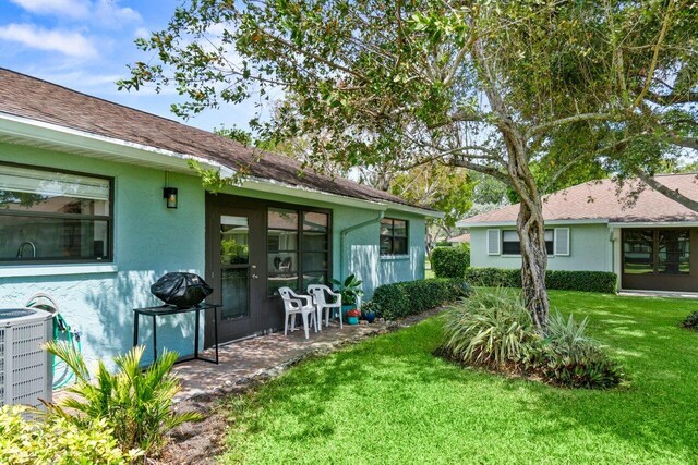 9750 Tabebuia Tree Dr Unit A, Boynton Beach, FL 33436 - rear view of property with stucco siding, a yard, and cooling unit