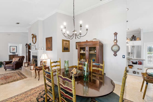 dining space with a chandelier, ornamental molding, light tile patterned floors, and a fireplace
