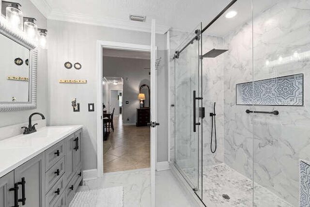 full bathroom with crown molding, vanity, marble finish floor, baseboards, and a marble finish shower