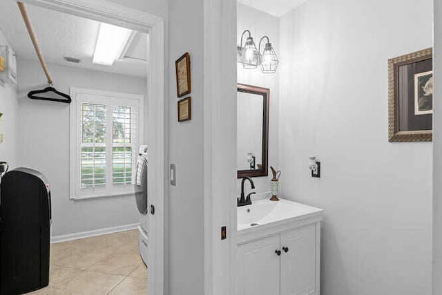 bathroom with vanity, baseboards, and tile patterned flooring